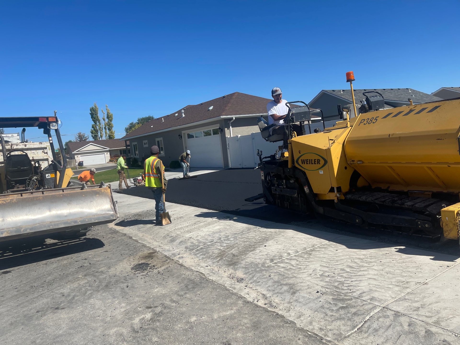 J&R crew laying fresh asphalt in a residential driveway
