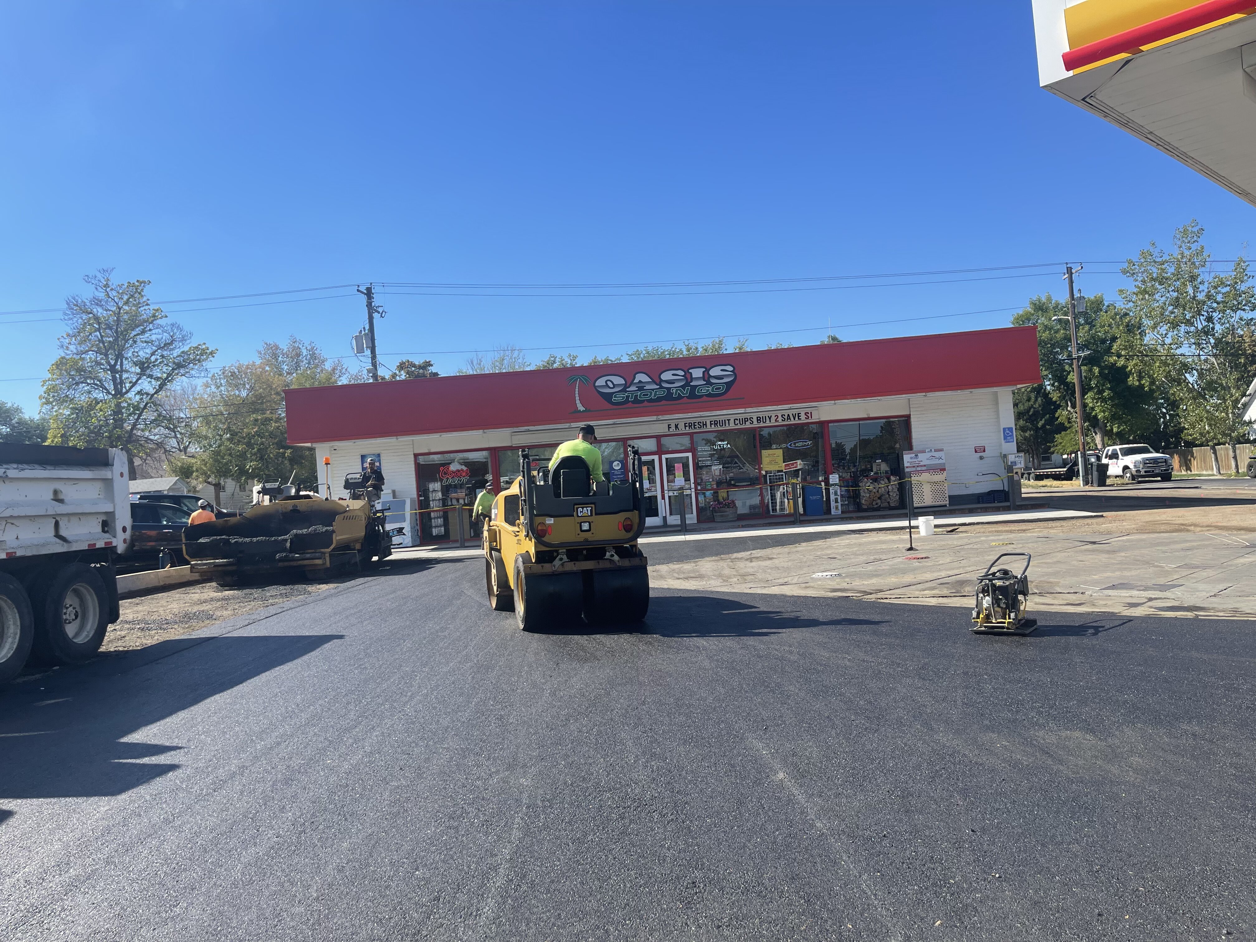 Asphalt roller compacting fresh pavement at Oasis